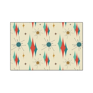 May include: Rectangular rug with a retro atomic design. The rug features a cream background with repeating patterns of red, teal, and gold diamonds, starbursts, and star shapes. The rug is a decorative floor covering.