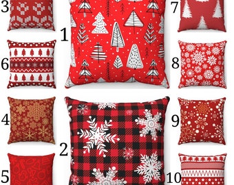 May include: Ten square decorative cushions with festive Christmas designs. The cushions display patterns such as snowflakes, Christmas trees, and geometric and knitted motifs, in red, white, and gold colours.
