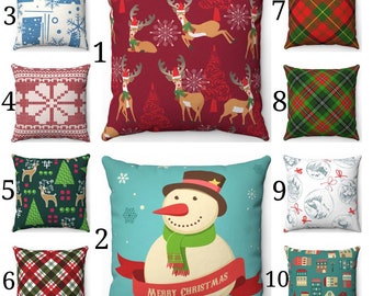 May include: A selection of ten square decorative cushions with festive Christmas designs. Designs include reindeer, snowflakes, Christmas trees, tartan patterns, a snowman, and a village scene. Colours include red, green, blue, and white.