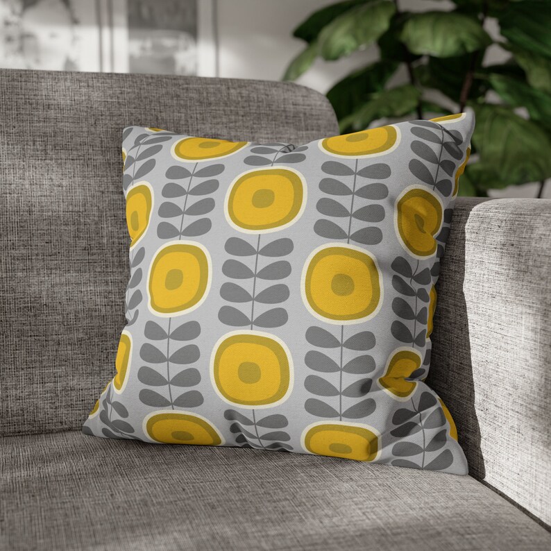 May include: A gray and yellow throw pillow with a geometric pattern of stylized flowers and leaves.