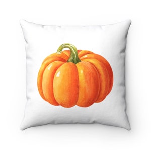 May include: Square white pillow featuring a watercolor painting of a vibrant orange pumpkin with a green stem. The pumpkin is the focal point, set against a clean white background. A seasonal decorative item.