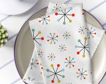 Puede incluir: Servilletas de tela blancas con un patrón repetido de estrellas de mediados de siglo moderno en negro, rojo, amarillo y azul.
