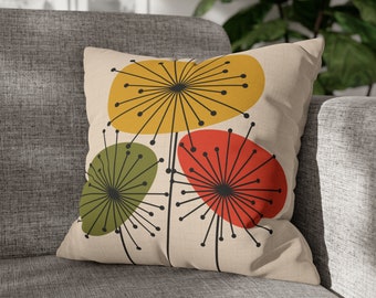Op de afbeelding: Een beige kussen met een gestileerd bloemenontwerp met drie abstracte bloemen in geel, groen en rood.