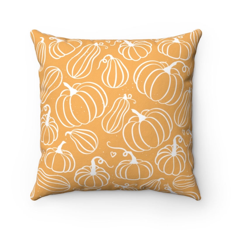 May include: Square throw pillow with a repeating pattern of white line-drawn pumpkins and gourds on an orange background. The pillow has a soft, inviting appearance, perfect for fall decor.