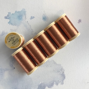 May include: Six spools of metallic gold thread, each with a white label and the text "N°4U METAL 130".