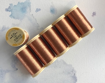 May include: Six spools of metallic gold thread, each with a white label and the text "N°4U METAL 130".