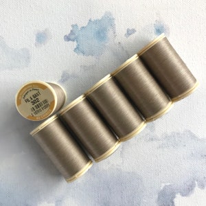 May include: Six spools of gray thread, labeled "FIL A GANT 302" with a barcode and "AU CHINOIS" printed on the label.