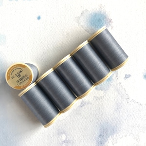 May include: Six spools of gray thread, each with a label that reads "FIL A GANT 130" and "AU CHINOIS".