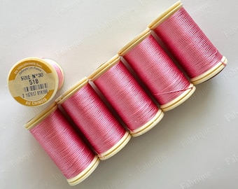 May include: Six spools of pink silk thread, with one spool positioned separately. The spools have a cream-colored base and are labeled with text including "SOIE N°30 518" and "AU CHINOIS".