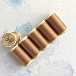 May include: Six spools of brown thread, each labeled "Fil a Gant 280" with a barcode and "Au Chinois" printed on the label.