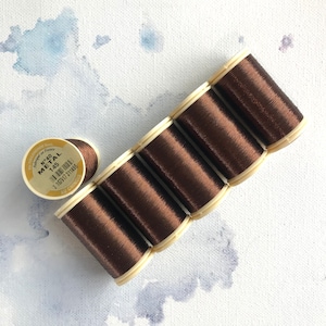 May include: Six spools of brown metallic thread, each labeled "No. 40 Metal 145" with a barcode and "Au Chinois" printed on the label.