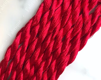 May include: A bundle of red embroidery floss, a type of thread used for hand embroidery.