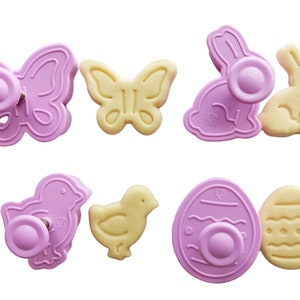 May include: Set of eight pink and yellow plastic cookie cutters shaped like a butterfly, bunny, chick, and egg. The cutters have a spring-loaded plunger to easily cut out shapes from cookie dough.