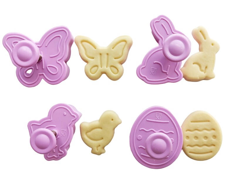May include: Set of eight pink and yellow plastic cookie cutters shaped like a butterfly, bunny, chick, and egg. The cutters have a spring-loaded plunger to easily cut out shapes from cookie dough.