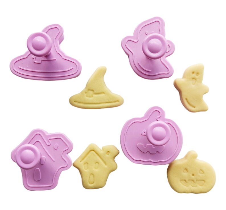 May include: A set of eight pink and yellow Halloween cookie cutters. The cutters are shaped like a ghost, a witch's hat, a pumpkin, a house, and a ghost.