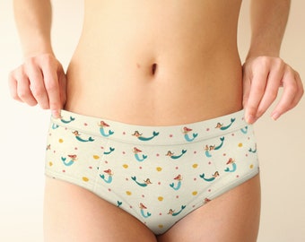 May include: White underwear with a pattern of mermaids and seashells.