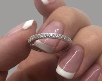 Puede incluir: Un fino anillo de banda de plata con una fila de pequeñas piedras de circonita cúbica transparentes.