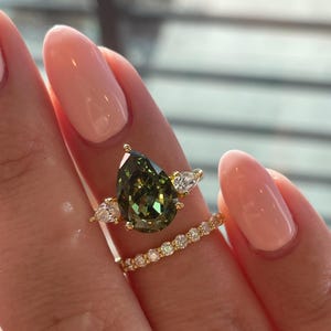 Förlovningsring med tre stenar, brudset med päronformad krossad is, olivgrön simulerad diamant och moissanit