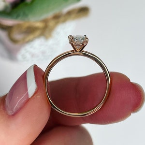 Puede incluir: Un anillo de compromiso de oro rosa con un solo diamante redondo.