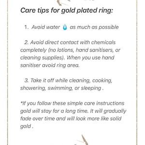 May include: A white informational card with a gold border and leaf illustrations at the top and bottom. The text reads: Care tips for gold plated ring: 1. Avoid water as much as possible. 2. Avoid direct contact with chemicals. 3. Take it off while cleaning, cooking, showering, swimming, or sleeping. It includes a note about gold fading over time.