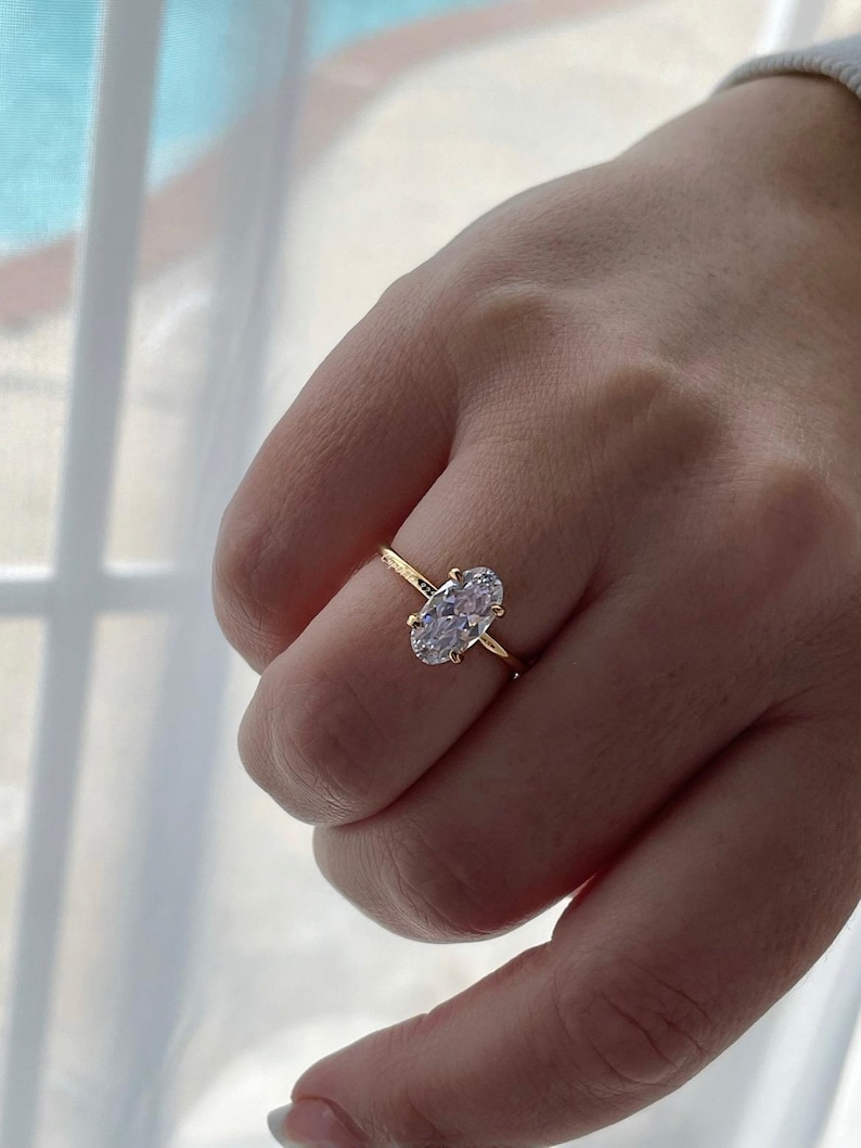 Puede incluir: Un anillo de oro con una gran piedra preciosa ovalada transparente.