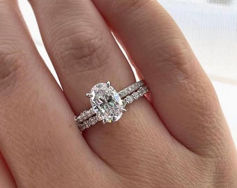 May include: A silver engagement ring set with a large oval-shaped diamond and a smaller diamond band.