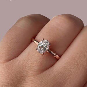 Puede incluir: Un anillo de oro rosa con una piedra preciosa ovalada transparente. El anillo est&aacute; grabado con el texto "CupOfTea925".