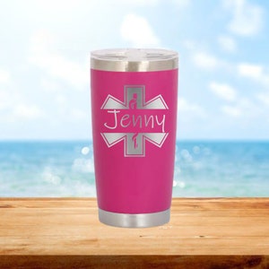 Puede incluir: Un vaso de acero inoxidable rosa con una estrella de la vida plateada y el nombre "Jenny" grabado en él.