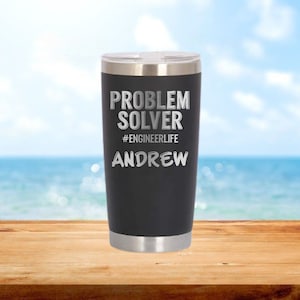 May include: A black stainless steel travel mug with a silver lid. The mug has the text "PROBLEM SOLVER #ENGINEERLIFE ANDREW" engraved on it.