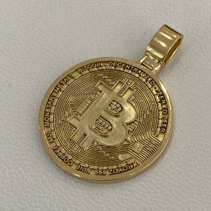Pode incluir: Pingente dourado com um design detalhado de um logotipo Bitcoin com o texto "Bitcoin Decentralized Peer to Peer" e "ZOROYZ 999 FINE COPPER" ao redor da borda.