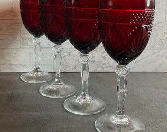 May include: Four red wine glasses with a clear crystal stem and base. The glasses have a diamond-shaped pattern.