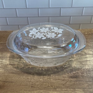 May include: A clear glass casserole dish with a lid. The lid has a floral design etched into it.