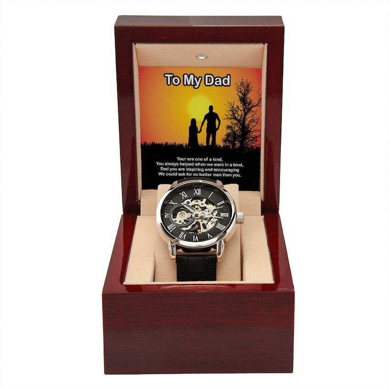May include: A black and silver watch with a skeleton movement, presented in a wooden box with a message that reads "To My Dad". The message includes a silhouette of a father and child walking into a sunset.
