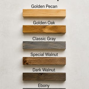 May include: Image showing stain color options for wood. The options include Golden Pecan, Golden Oak, Classic Gray, Special Walnut, Dark Walnut, and Ebony. Each color is displayed on a rectangular wooden block.