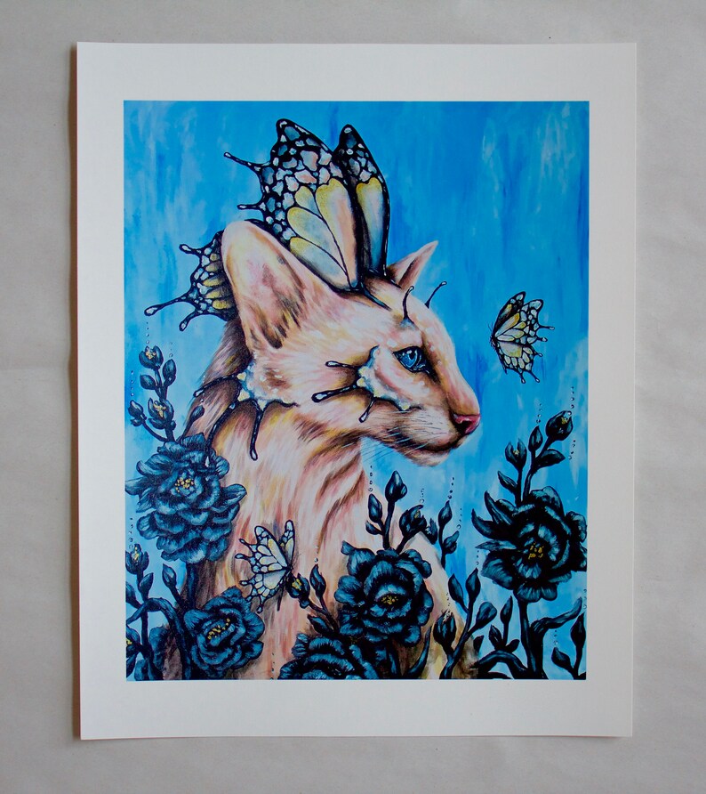 Puede incluir: Un gato blanco con alas de mariposa y ojos azules est&aacute; rodeado de flores azul oscuro y mariposas. El fondo es una acuarela azul claro.