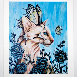 Puede incluir: Un gato blanco con ojos azules y alas de mariposa est&aacute; rodeado de flores azul oscuro. El gato est&aacute; mirando hacia la derecha de la imagen. El fondo es azul claro.