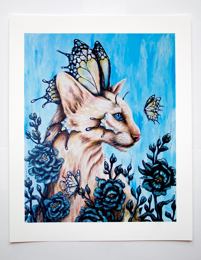 Puede incluir: Un gato blanco con ojos azules y alas de mariposa est&aacute; rodeado de flores azul oscuro. El gato est&aacute; mirando hacia la derecha de la imagen. El fondo es azul claro.