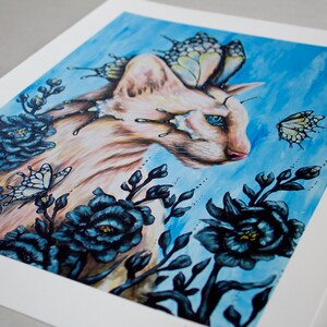 Puede incluir: Un gato blanco con ojos azules y alas de mariposa est&aacute; rodeado de flores azul oscuro sobre un fondo azul claro.