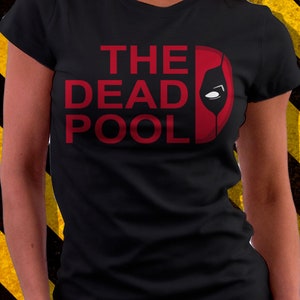 May include: Black t-shirt with a red graphic that says "THE DEAD POOL" with a red Deadpool mask silhouette.