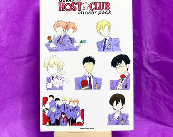 May include: A sticker pack featuring illustrations of characters from Ouran High School Host Club. The stickers depict various characters in purple uniforms, some holding roses or a stuffed bunny. The pack is displayed on a small wooden easel.