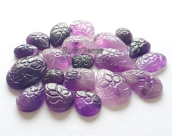 May include: A collection of 18 carved amethyst gemstones in various shades of purple. The gemstones are carved with intricate floral designs and are ideal for jewellery making or crafting.