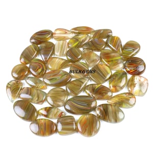 May include: A selection of polished gemstones in diverse shapes, such as oval, teardrop, and round. The stones display a blend of brown, yellow, and orange tones with a striped design. The text "BULKGEMS" is visible.