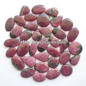 May include: A collection of 30 pink and green gemstone cabochons in various shapes and sizes. The gemstones are smooth and polished, with a natural, organic look.