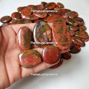 May include: A collection of red, green and brown jasper cabochons, with a variety of patterns and textures. The cabochons are oval shaped and have a smooth, polished finish.