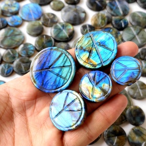 Può includere: Una collezione di ciondoli a forma di segno della pace in labradorite, una pietra preziosa iridescente blu e verde. Le pietre sono lucidate e hanno una finitura liscia e lucida.