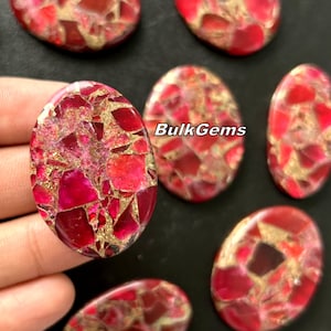 May include: Oval shaped cabochon gemstones with a red and gold color pattern. The stones have a speckled appearance with a mix of red and gold colors.
