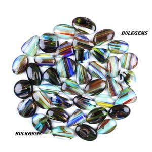 May include: A selection of colourful glass cabochons in various shapes, including oval, teardrop, and irregular forms. The cabochons feature a mix of colours, including blue, green, red, and gold, with striped and swirled patterns. The text "BULKGEMS" is visible.