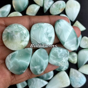 May include: A collection of green and white cabochon gemstones with a variety of shapes and sizes. The stones have a swirling, marbled pattern. The image includes the text "BulkGems".