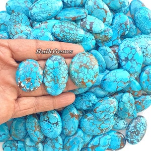 May include: A collection of oval-shaped turquoise cabochons with a blue and brown marbled pattern. The stones are smooth and polished, with a variety of sizes and shapes. The stones are arranged in a random pattern, with some overlapping. The stones are all natural and have a unique, organic look.