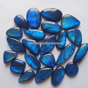 May include: A collection of 18 blue labradorite gemstone cabochons in various shapes and sizes. The stones have a shimmering, iridescent effect.
